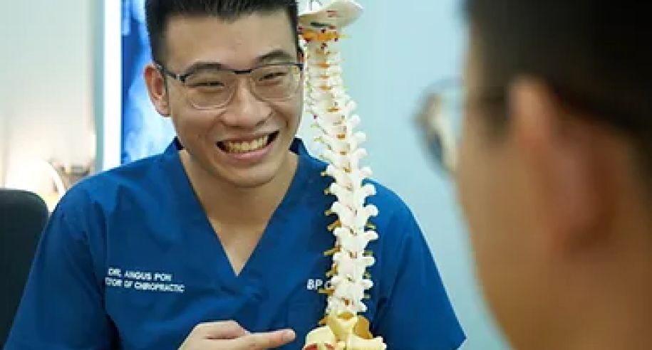 脊骨神经科医生用模型向患者讲解脊椎